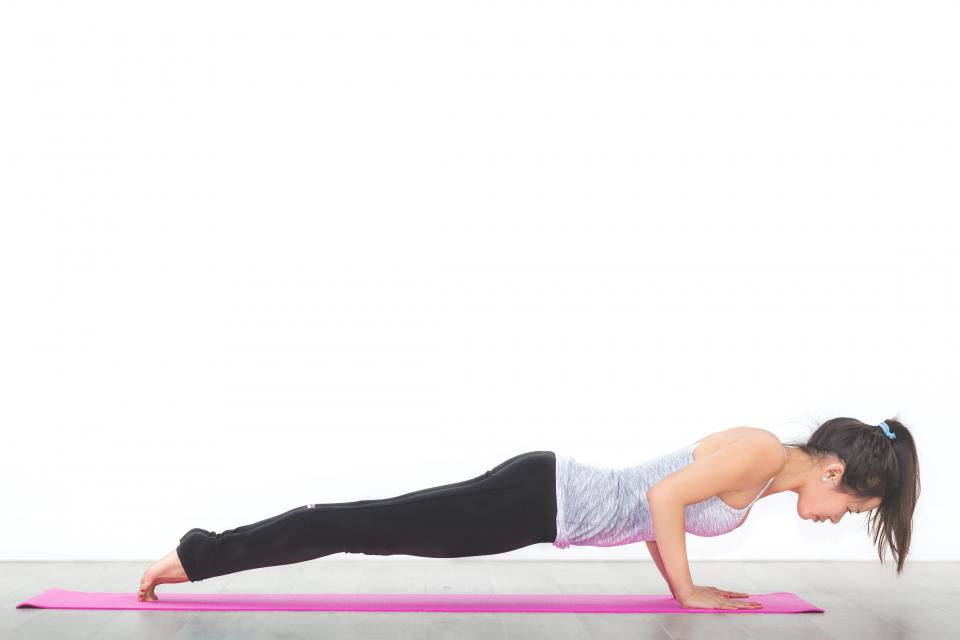 A woman holding a plank on a yoga mat
